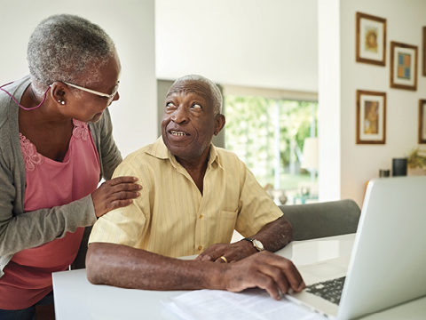 a couple talking together in front of a computer